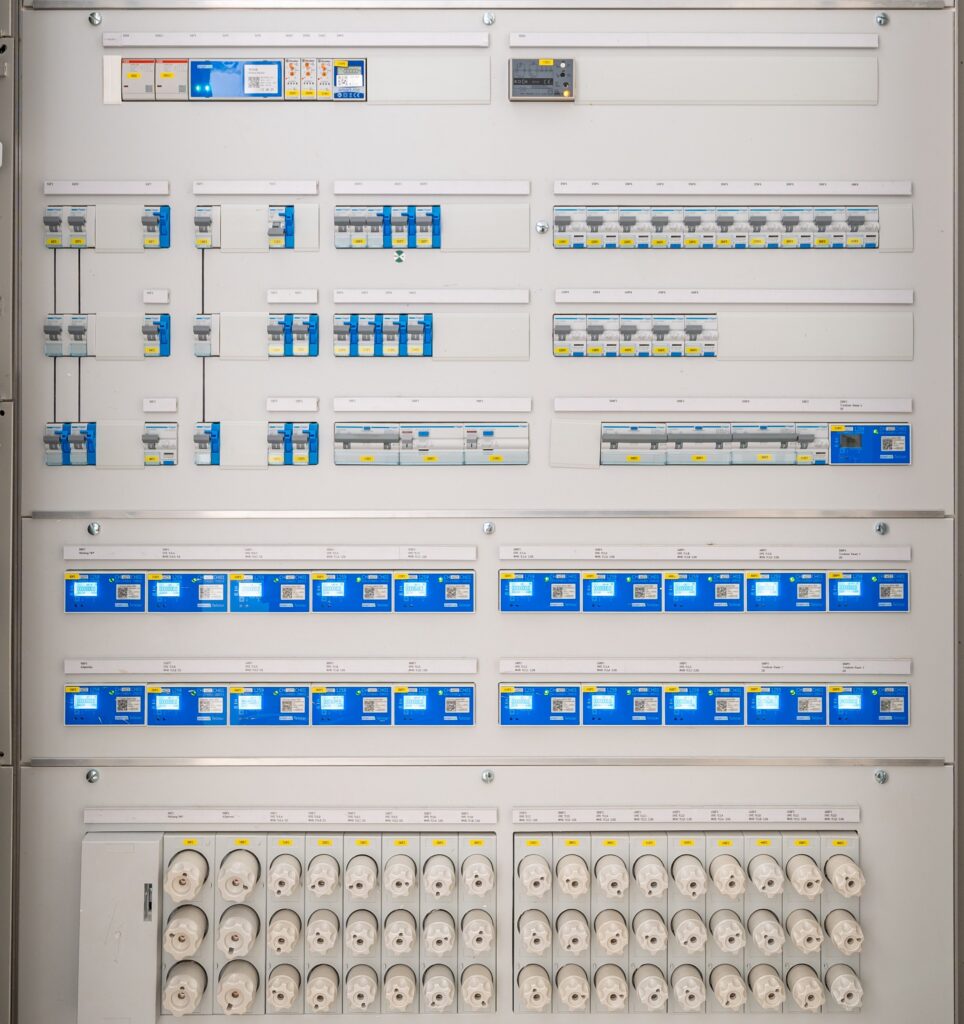 Harmonik Distorsiyon Nedir? IEEE 519 ve IEC 61000 Standardına Göre Ölçüm ve Çözüm | AYÇE Endüstriyel Detailed view of a modern electrical panel featuring circuit breakers and sockets for efficient energy distribution.